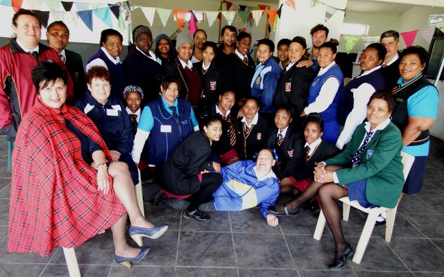 Die groep gemeenskaps-gesondheidwerkers in skooldrag tydens â€˜n werkswinkel, met voor links die kursusleier, Malinda Karsten en langs haar Ena Geldenhuys 